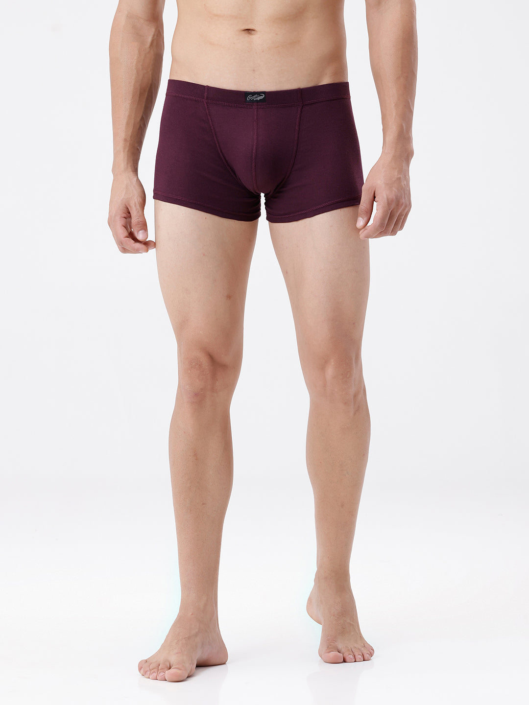 Man wearing a pair of burgundy boxer briefs on a white background