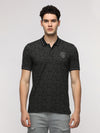 Man wearing a grey blotch pattern all over printed polo t shirt in grey on a light gray background