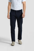 Person wearing navy pants and a gray shirt on a white background