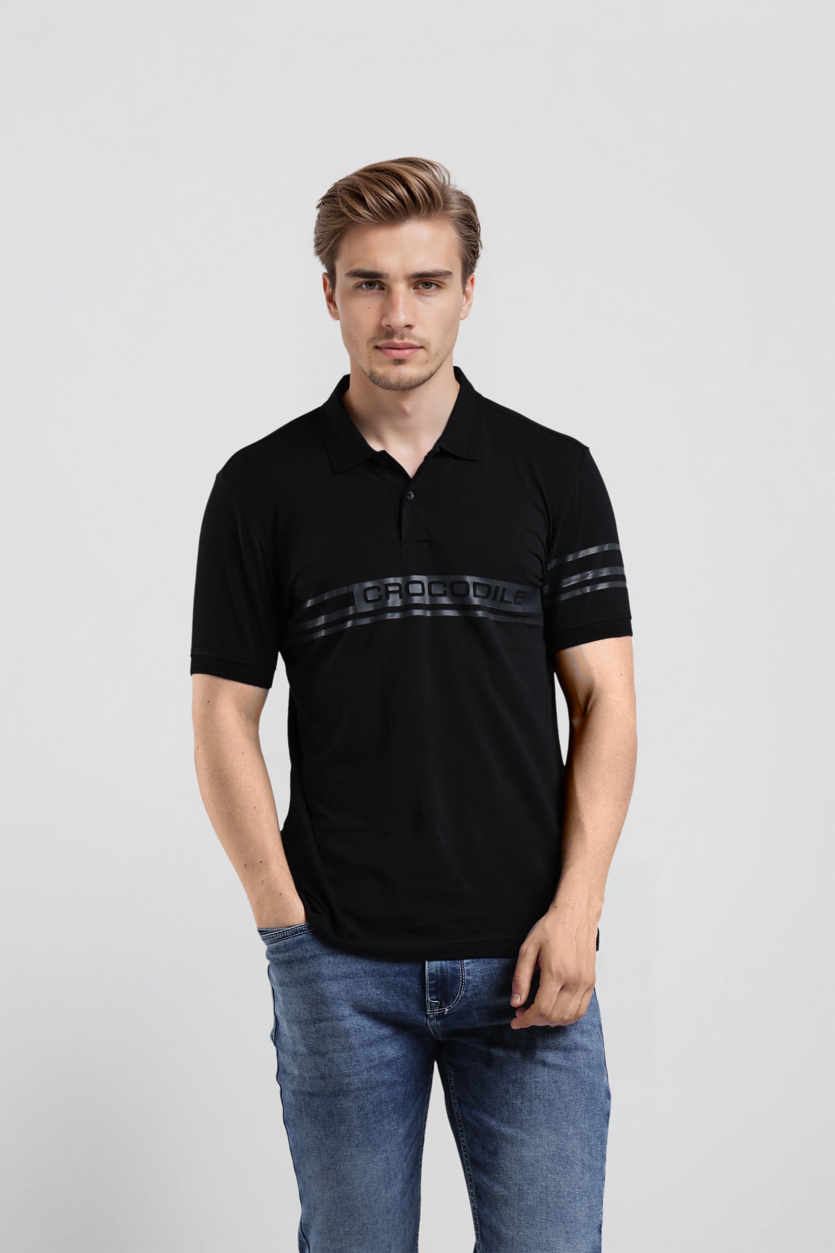 Man wearing a black polo shirt with a logo on a light gray background