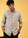 Man wearing a brown stone brown checked full sleeve 100% cotton shirt on a light gray background