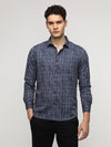Man wearing a navy navy geomentric grunge premium printed shirt on a light gray background