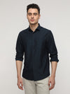 Man wearing a navy navy stripe permiumtechno shirt with casual styling on a gray background