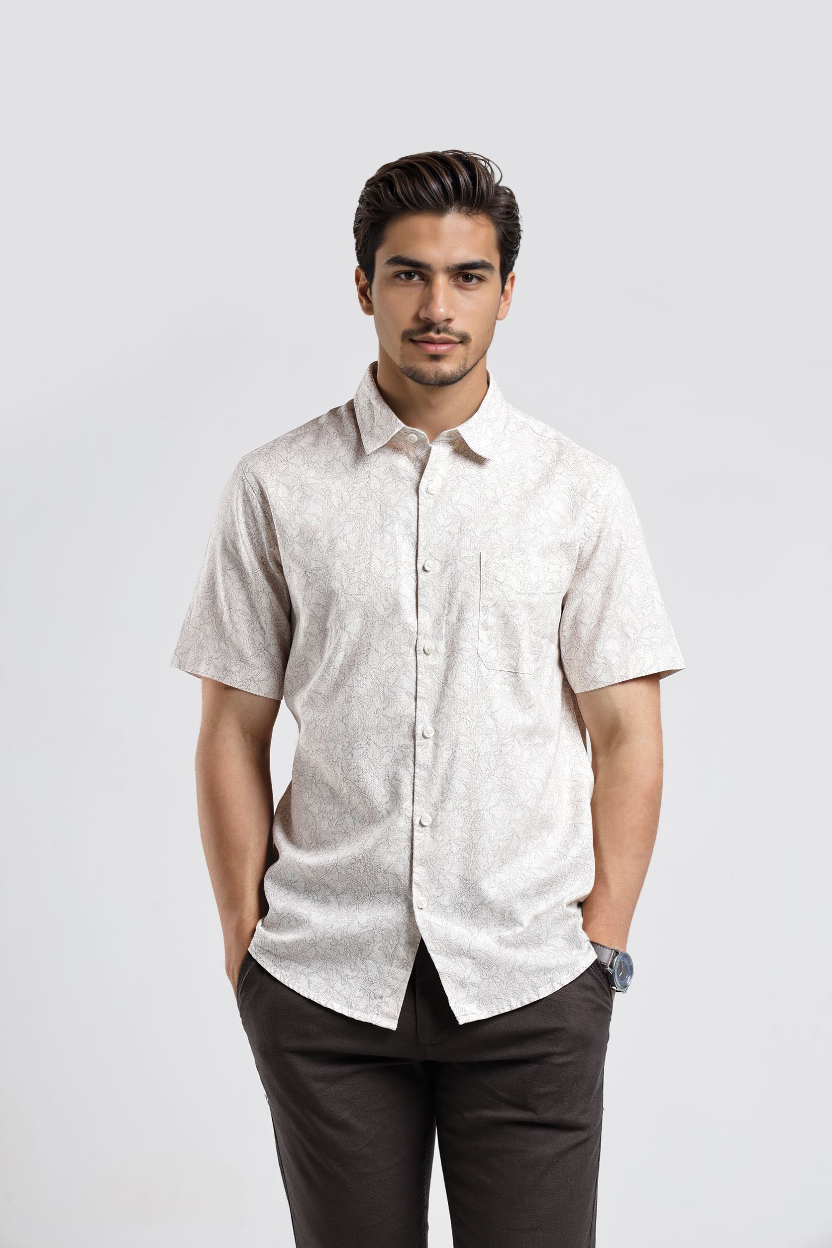 Man wearing a light-colored short-sleeve shirt and dark pants on a white background