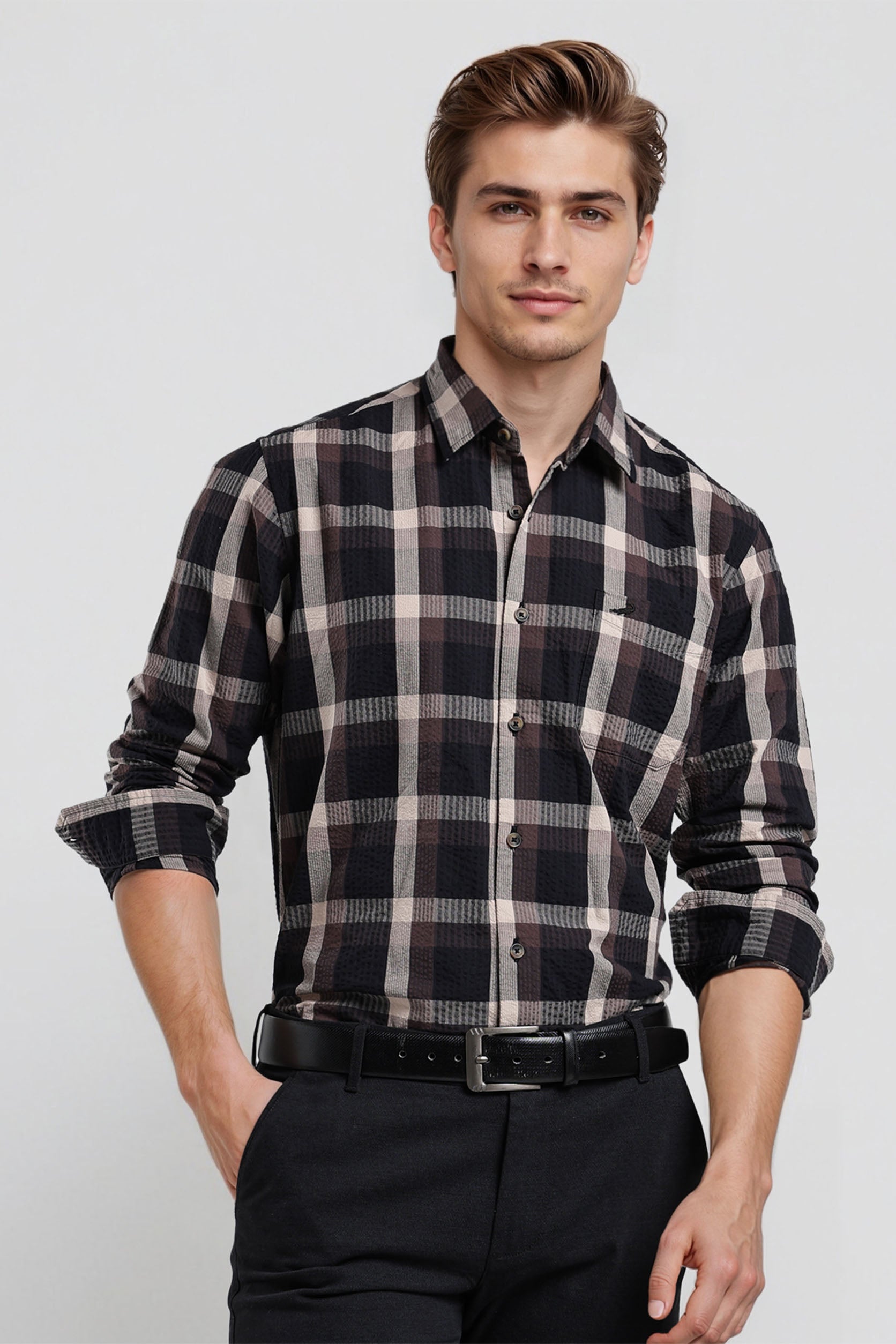 Man wearing a black and white plaid shirt with rolled-up sleeves on a white background