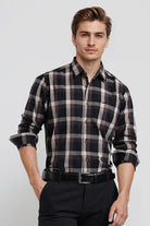 Man wearing a black and white plaid shirt with rolled-up sleeves on a white background