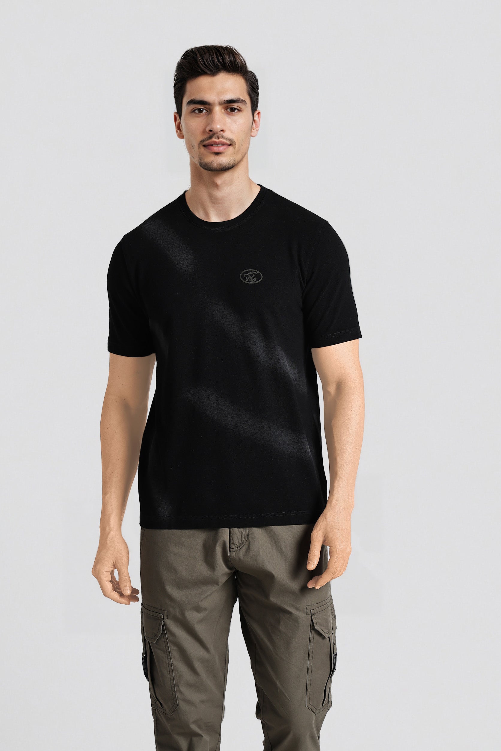 Man wearing a black t-shirt with a logo on a light gray background