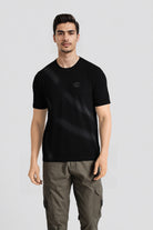 Man wearing a black t-shirt with a logo on a light gray background