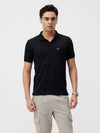 Man wearing a black solid black half sleeve casual polo t shirt with casual styling on a gray background