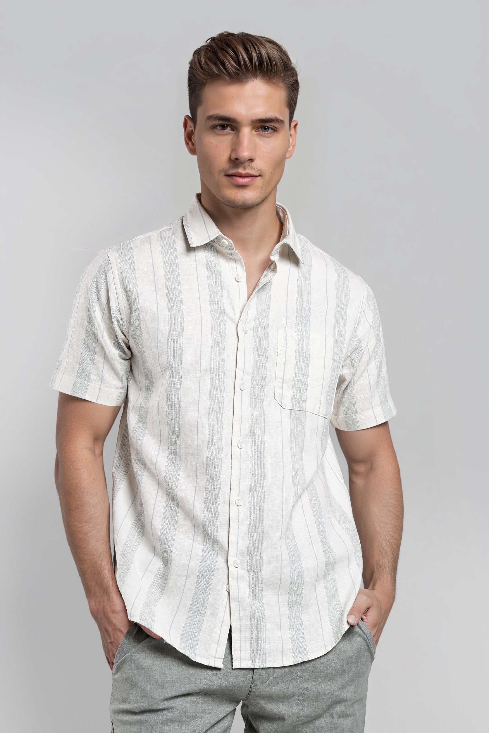 Man wearing a white striped shirt and gray pants on a gray background