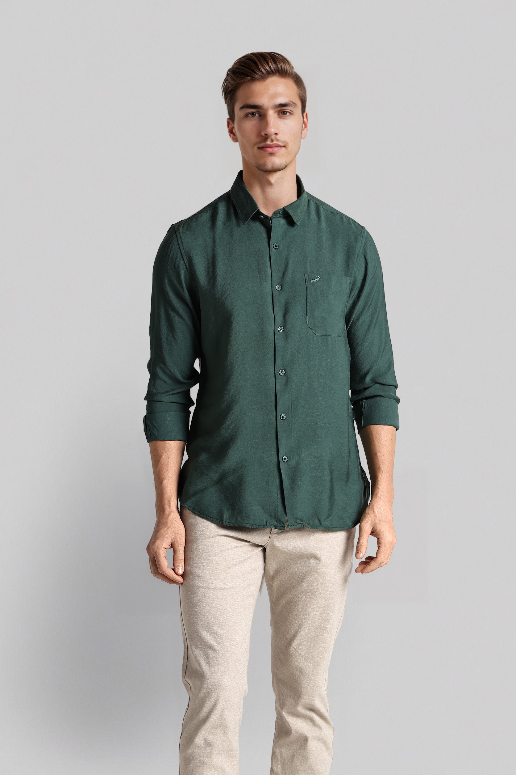 Man wearing a green shirt and beige pants against a gray background