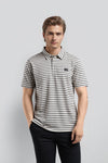 Man wearing a cream cream jacquard polo t shirt comfort fit polo t shirt with casual styling on a gray background