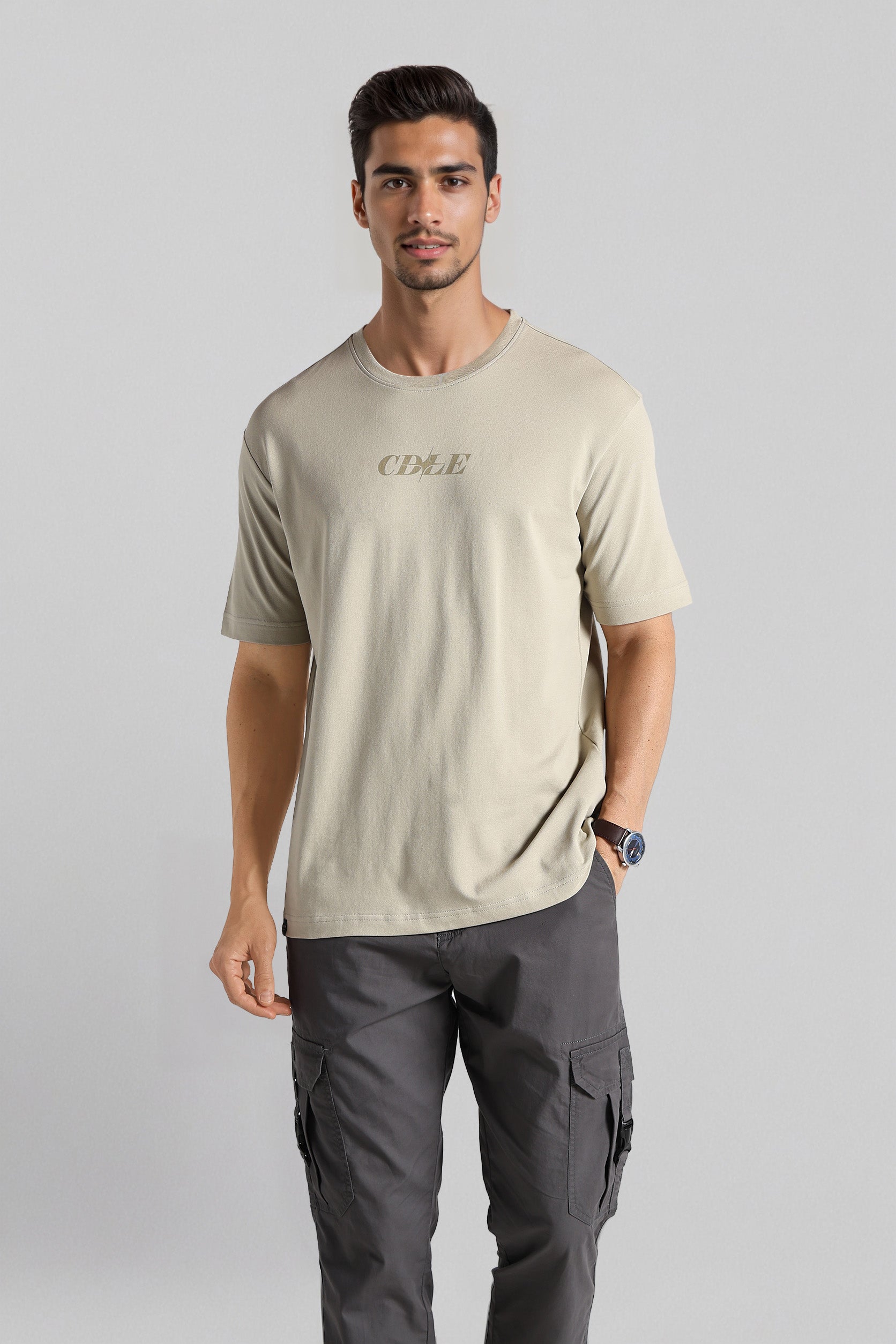 Man wearing a beige t-shirt and gray cargo pants on a light gray background