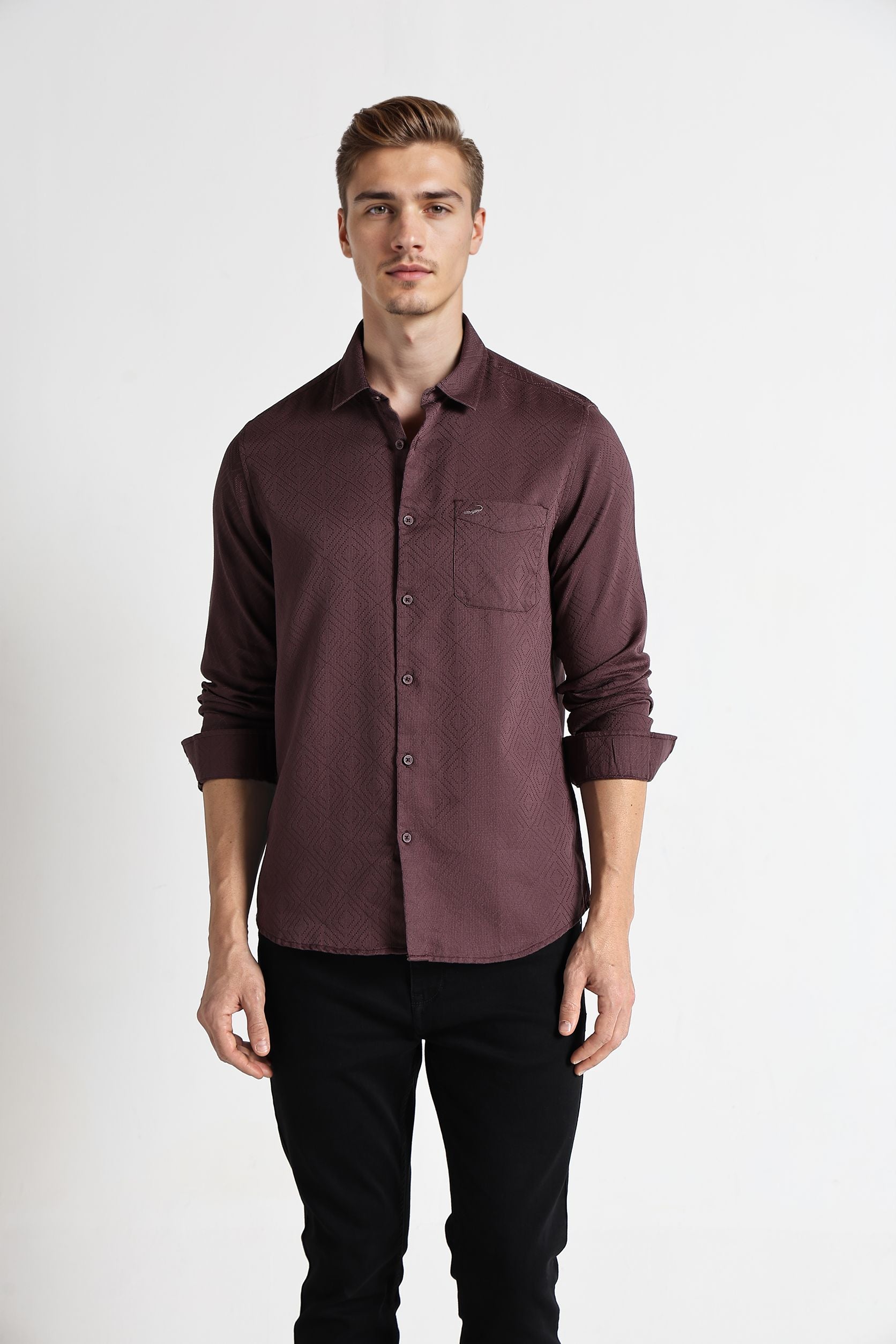 Man wearing a maroon button-up shirt and black pants on a white background