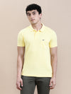 Man wearing a yellow yellow solid polo t shirt with pocket with casual styling on a gray background