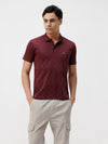 Man wearing a fig all over print slim fit polo t shirt with casual styling on a gray background