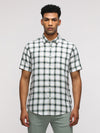 Man wearing a green half sleeve green checked shirt for casual elegance with casual styling on a gray background