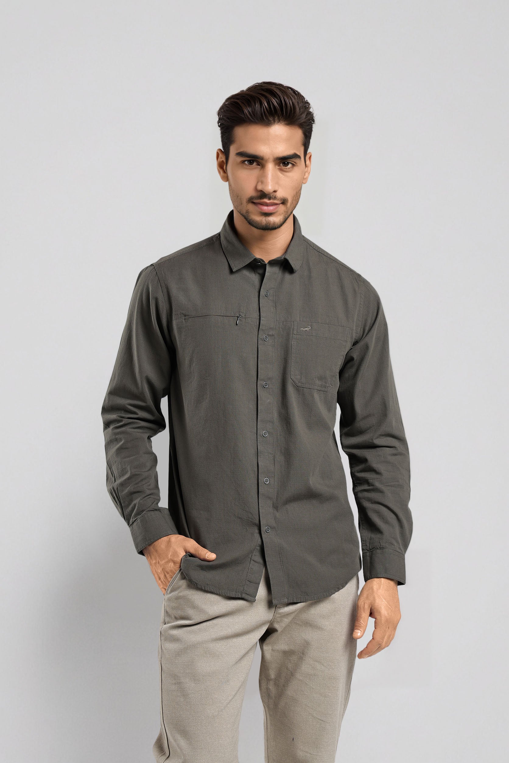 Man wearing a gray shirt and beige pants on a light gray background