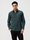 Man wearing a green textured windown pane checks shirt green on a light gray background