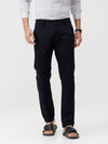 Man wearing a navy dark navy solid slim fit trousers on a light gray background