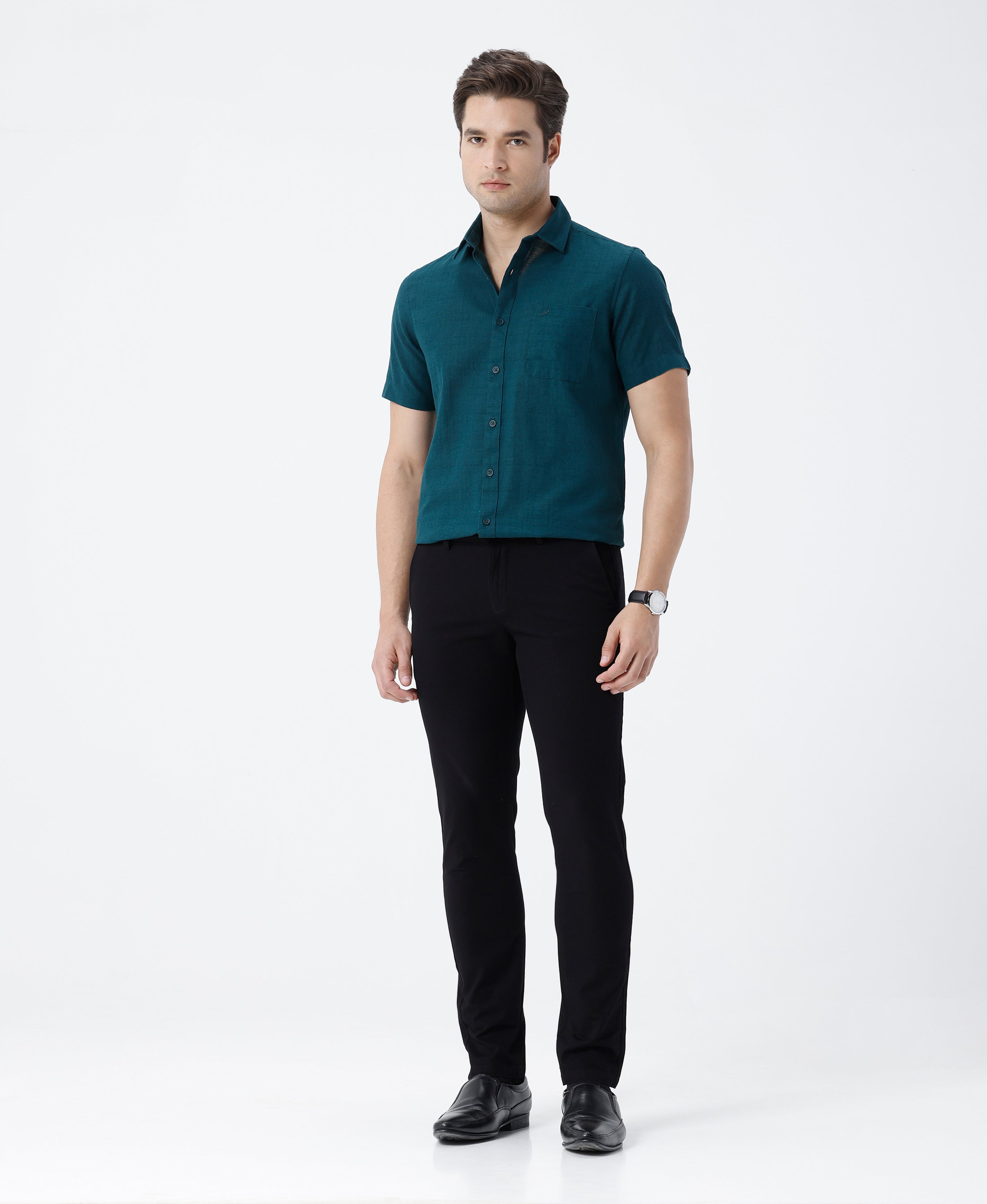 Man wearing a green pure cotton textured shirt green with casual styling on a gray background