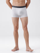 Person wearing white boxer briefs with a dark waistband on a white background