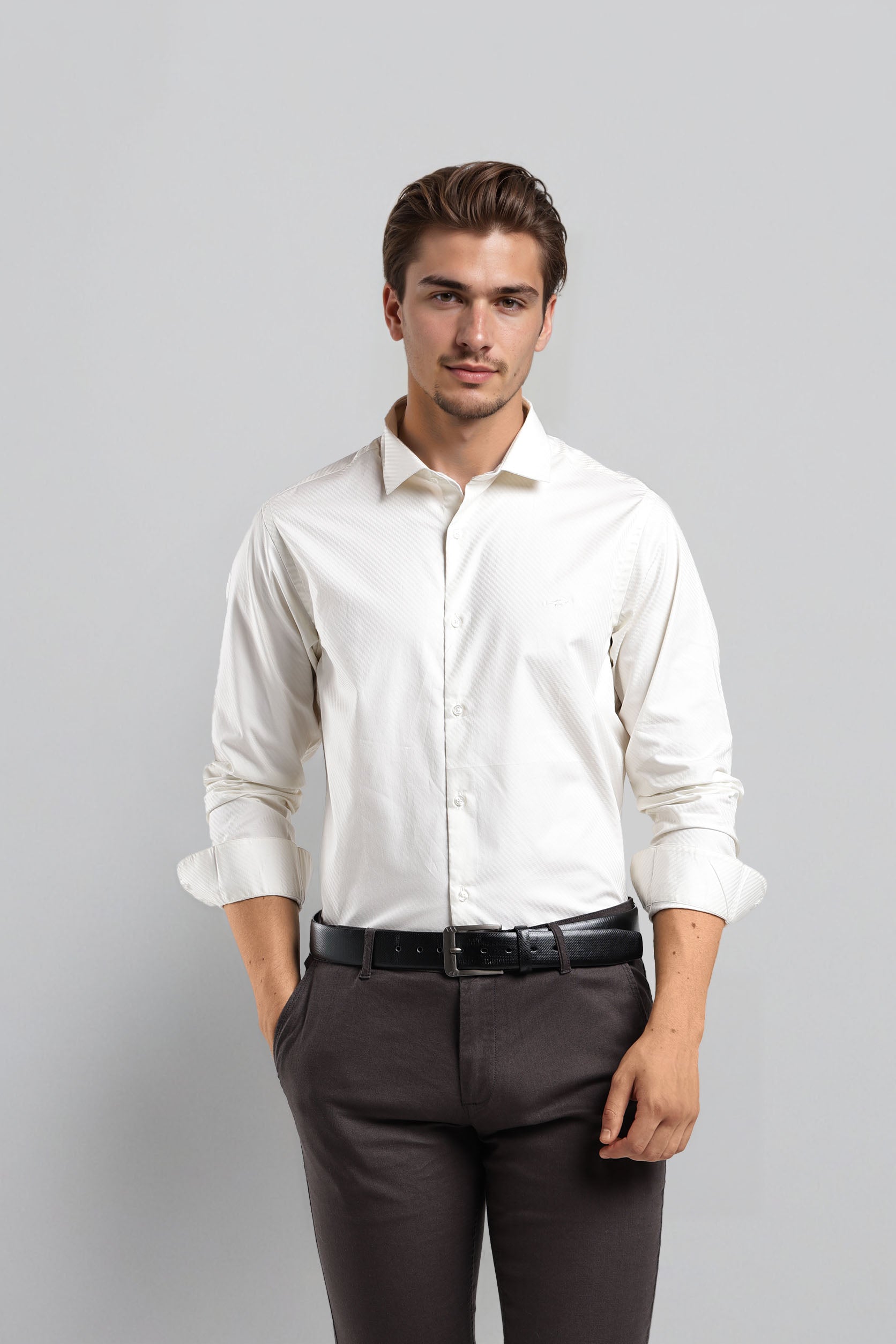 Man wearing a white dress shirt and dark pants against a gray background