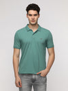 Man wearing a green solid sporty green slim t shirt with cotton poly with casual styling on a gray background