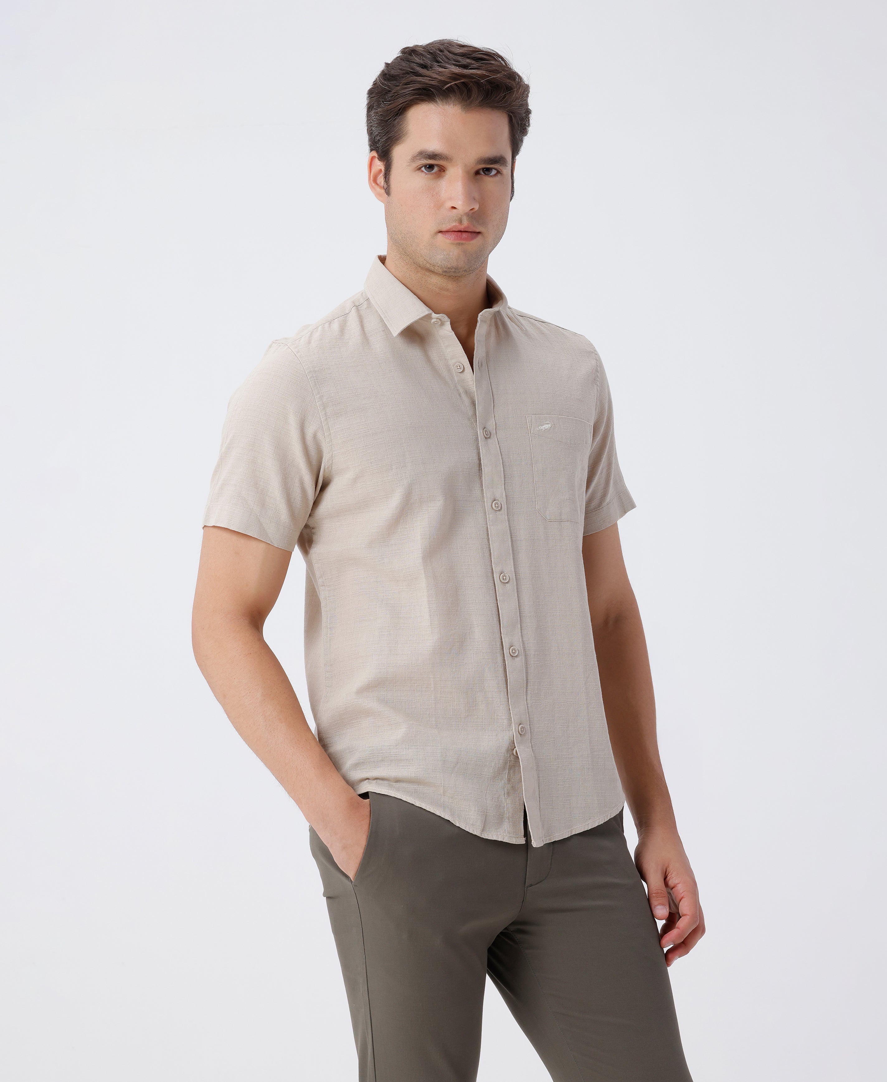Man wearing a beige pure cotton textured shirt beige on a light gray background