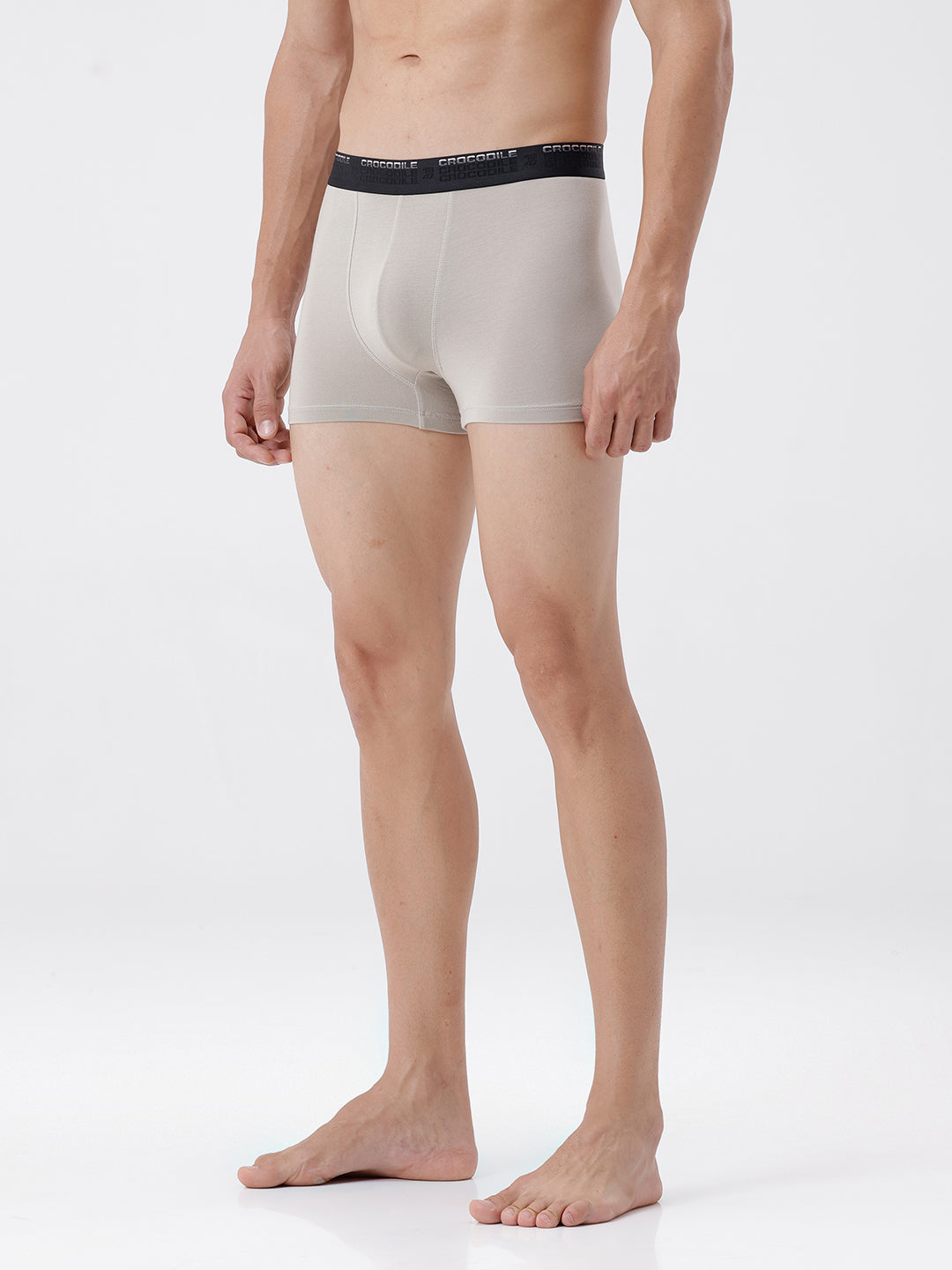 Man wearing beige boxer briefs with a black waistband on a white background