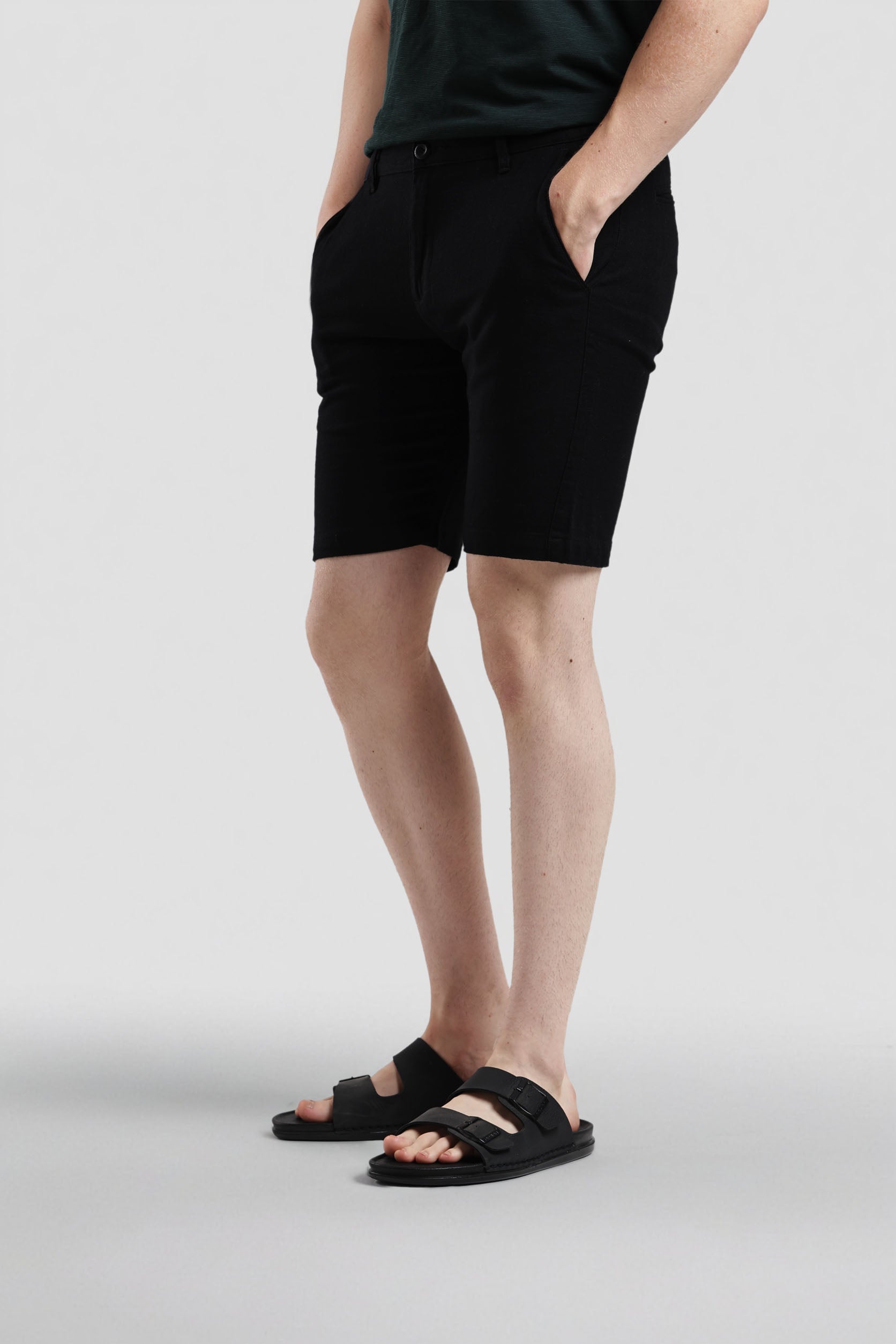 Person wearing black shorts on a light gray background