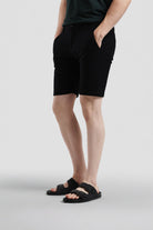 Person wearing black shorts on a light gray background