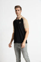 Man wearing a black and beige polo shirt on a white background