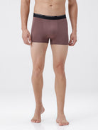Man wearing a pair of brown boxer briefs with a white background