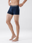 Man wearing navy blue boxer briefs on a white background