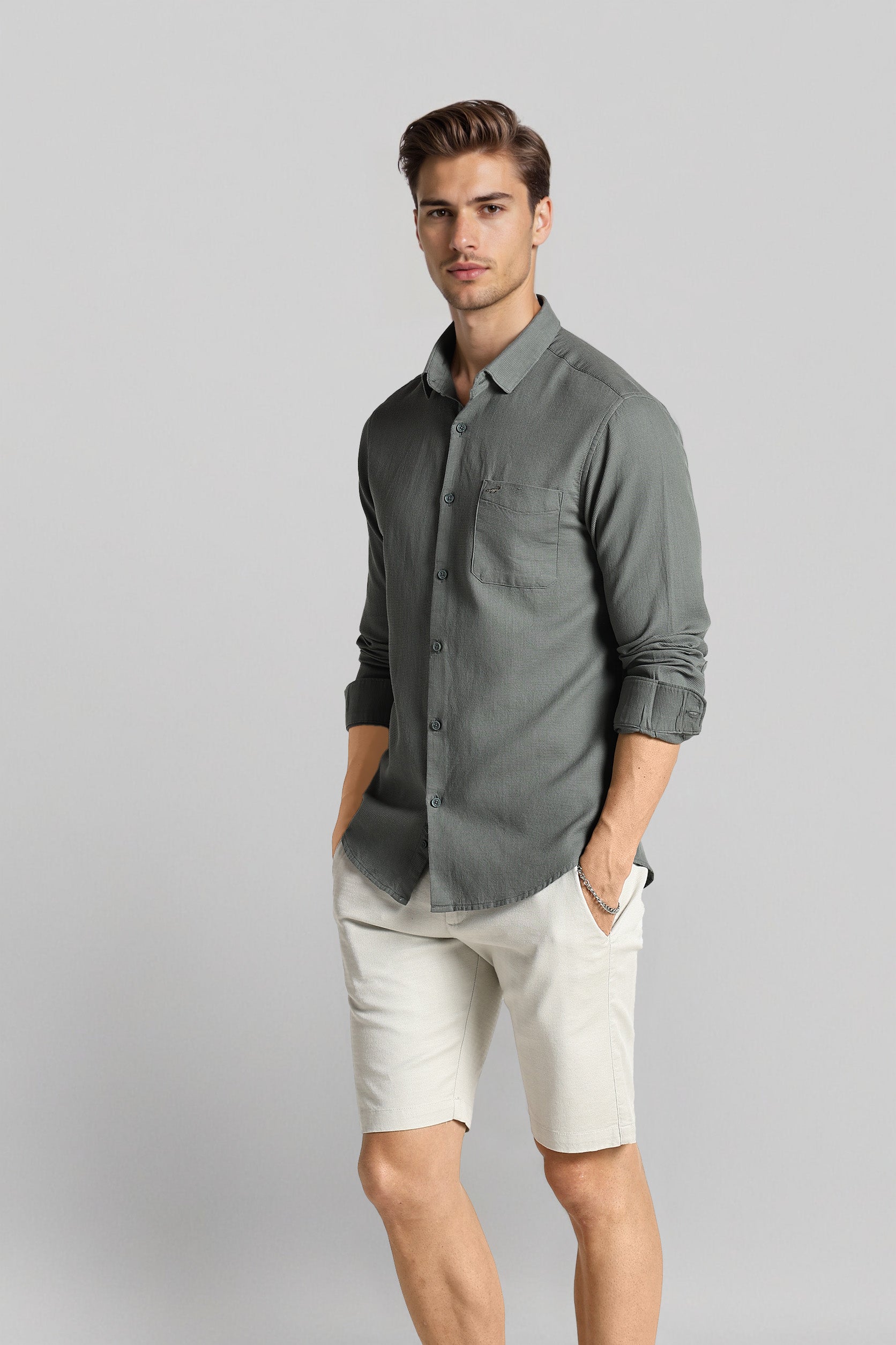 Man wearing a gray shirt and white shorts on a gray background