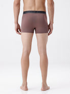 Man wearing brown boxer briefs on a white background