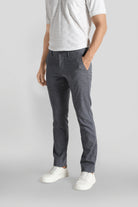 Person wearing gray pants and white shoes on a light gray background