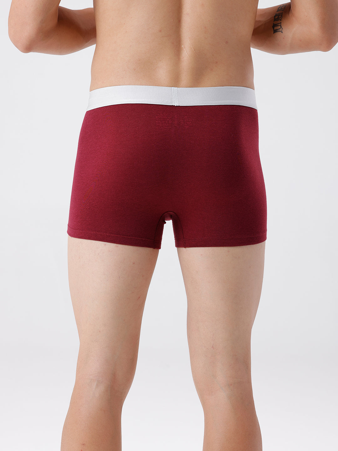 Maroon boxer briefs worn by a person on a white background
