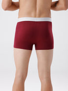 Maroon boxer briefs worn by a person on a white background