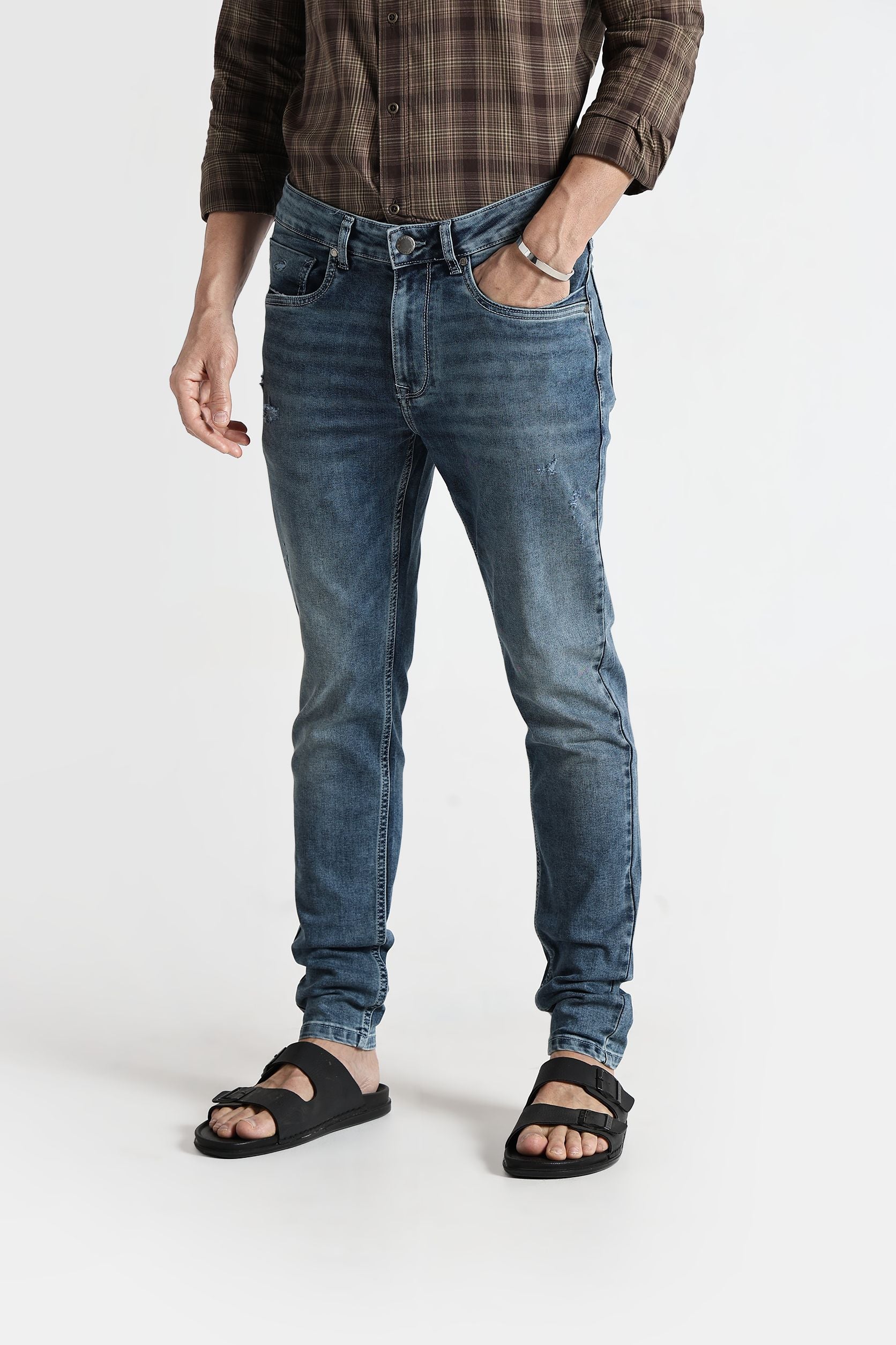 Person wearing blue jeans and a plaid shirt on a white background