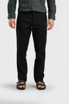 Person wearing black pants and a green shirt on a white background