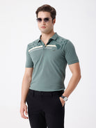 Man wearing a green iceberg green chest print slim fit polo t shirt on a light gray background
