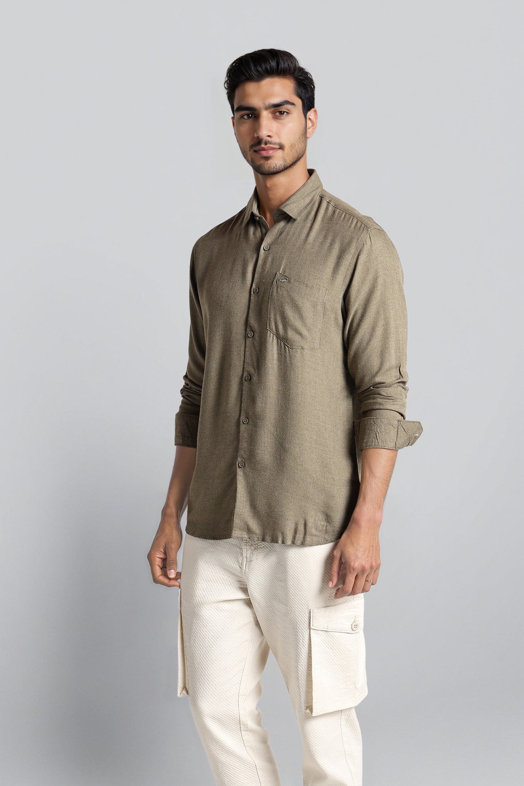 Man wearing a green shirt and white pants on a gray background