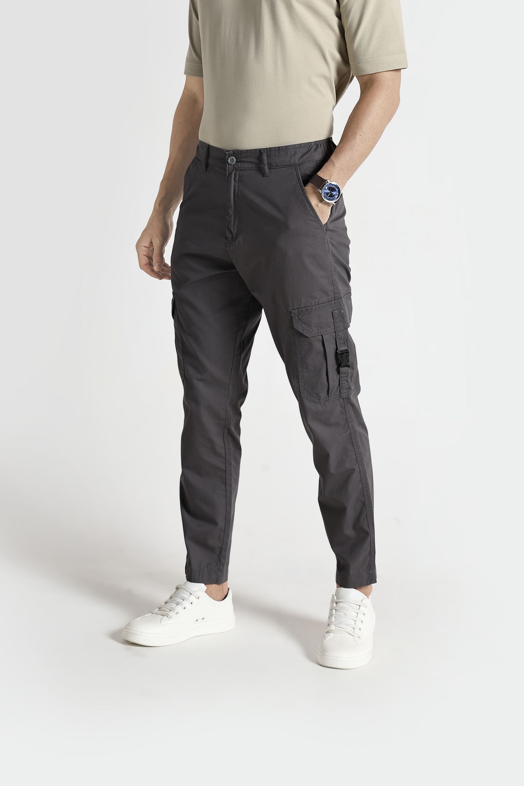Person wearing gray cargo pants on a white background