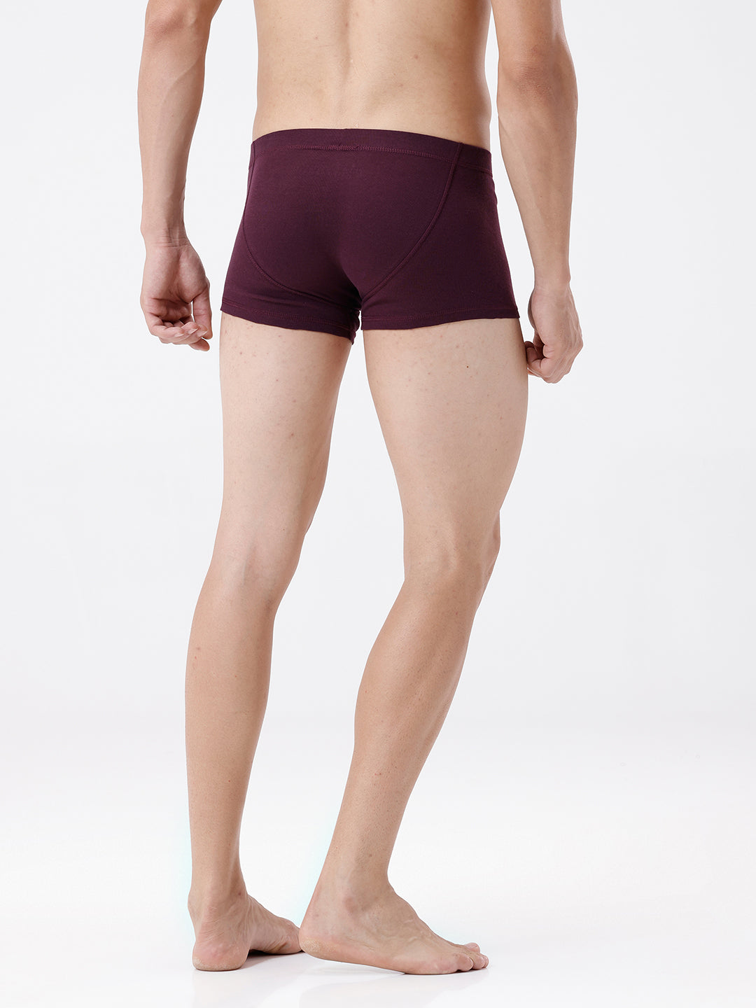 Person wearing maroon boxer briefs on a white background