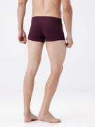 Person wearing maroon boxer briefs on a white background