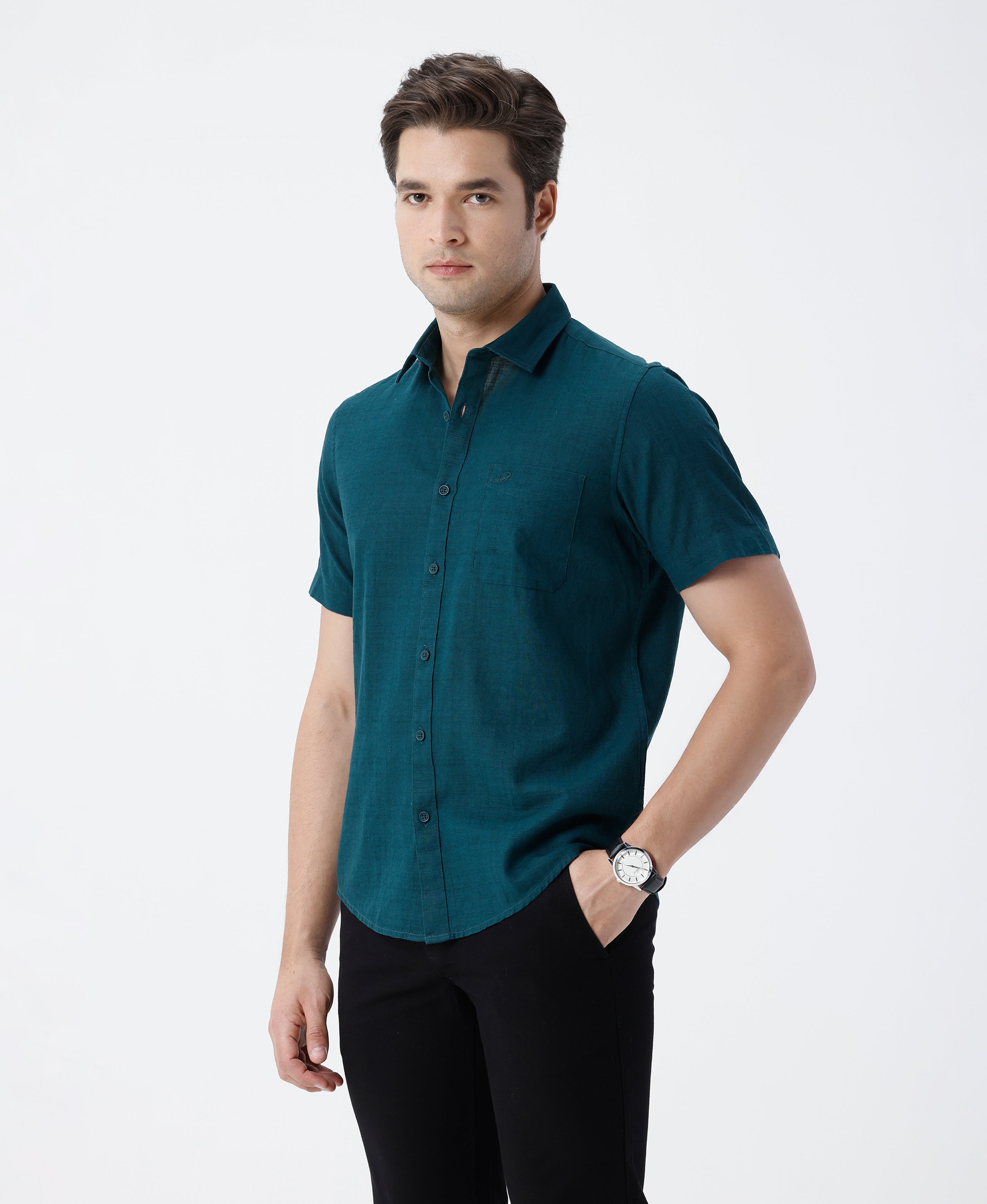 Man wearing a green pure cotton textured shirt green with casual styling on a gray background