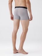 Person wearing gray boxer briefs with black waistband on a white background