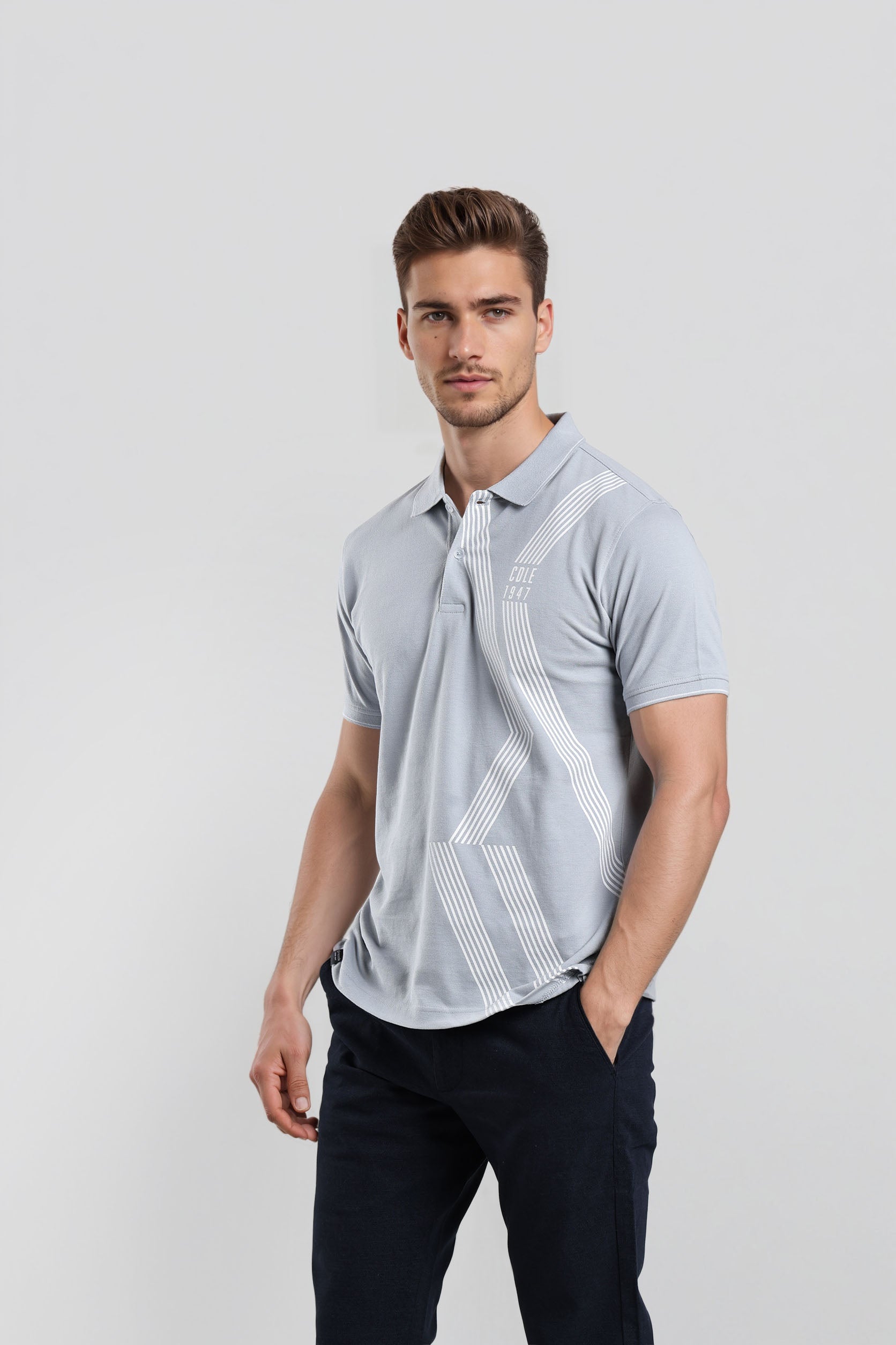 Man wearing a light blue polo shirt with geometric patterns on a white background